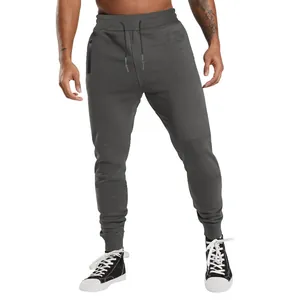 Full view of men's charcoal grey drawstring joggers with zipper pockets on model
