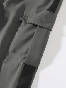 Detail of cargo pants pocket showing durable grey fabric and contrast black side stripe.