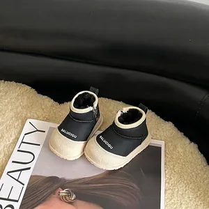 Close-up of warm black and cream fleece-lined baby snow boots with side zippers