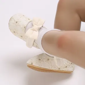 Gros plan de chaussures de princesse pour bébé avec dentelle florale et joli nœud