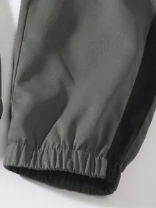 Close-up of elasticated ankle cuff on grey cargo pants with black stripe