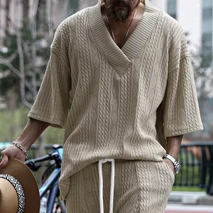 Vue détaillée du col en V surdimensionné et de la maille torsadée sur un haut beige pour hommes