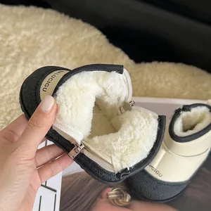 Close-up of warm beige baby snow boots with thick white faux fur lining and side zipper