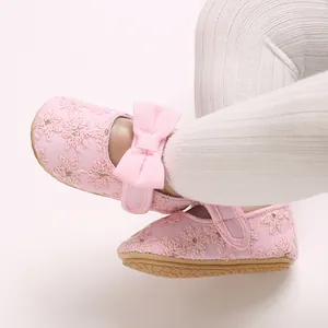 Vue détaillée de chaussures de bébé fille roses avec broderies de fleurs et un grand nœud
