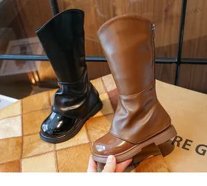 Dettaglio delle eleganti scarpe Martin alte nere e marroni per bambine in inverno