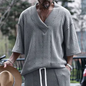 Gros plan d'un t-shirt tricoté gris pour hommes avec col en V profond et motif torsadé.