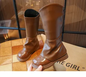 Vista dettagliata di stivali alti marroni alla moda per bambine con punta lucida
