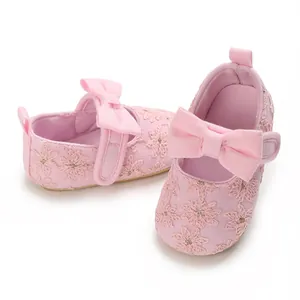 Vue détaillée de chaussures de princesse roses pour bébé avec nœud et broderie florale