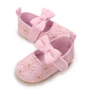 Détail de chaussures bébé roses en dentelle florale avec nœud doux et semelle souple