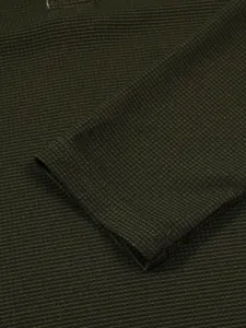 Nahaufnahme der Waffelstrickstruktur eines olivgrünen Herren-Langarm-Poloshirts.