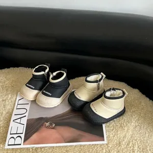 Detail view of children's fleece-lined winter snow boots in black and beige