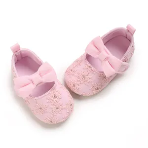 Vue détaillée de chaussures de princesse roses pour bébé avec broderie et nœud.