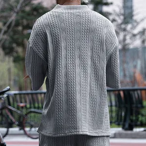 Détail de la vue arrière du t-shirt tricoté gris ample pour homme avec motifs torsadés