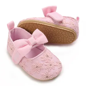 Détail de chaussures de princesse roses pour bébé avec broderie et un joli nœud.