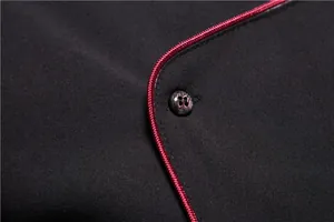 Close-up detail of a business casual black shirt featuring red piping and a sleek button