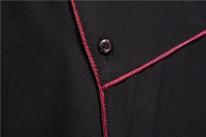 Close-up detail of men's black business casual shirt with decorative red piping.