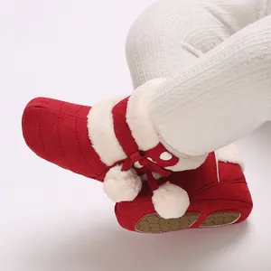 Close-up of red baby winter fleece boots featuring white pom-poms and cozy plush lining.