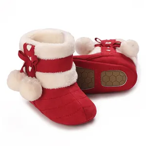 Red baby winter boots featuring white faux fur trim, decorative bow and pom-poms