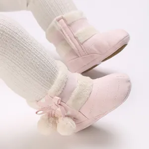 Detailed view of pink baby winter boots featuring soft plush lining and pom-pom accents
