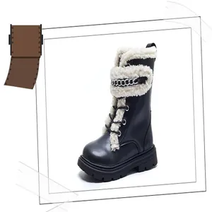 Close-up of children's black Martin boots with white sherpa trim and silver chain.