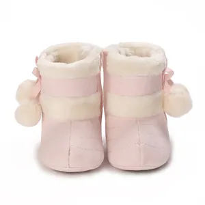 Close-up of pink baby winter boots with soft plush lining and cute pompom details