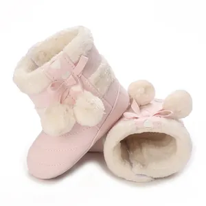 Detail of pink baby winter boots with soft white fleece lining and cute pom-pom bows
