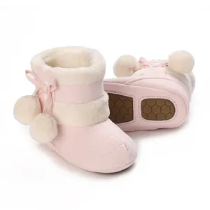 Detail of pink fur-lined baby winter boots with non-slip sole and pom-pom decor