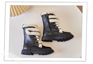 Side detail of black children's Martin boots featuring curly faux fur trim and silver chains
