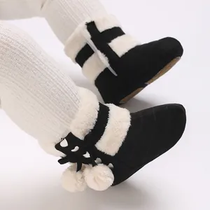 Warm black winter baby boots featuring white faux fur trim and cute decorative pom-poms