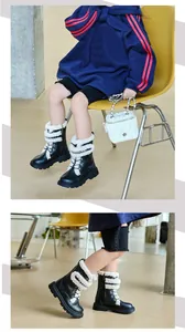 Detailed view of children's black Martin boots featuring warm fleece and chain accents