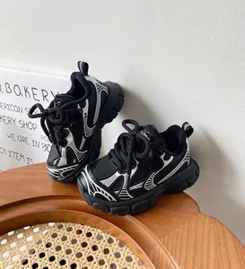 Primer plano de zapatillas chunky para niños en blanco y negro con textura de malla y suela.