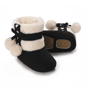 Close-up view of warm baby winter boots featuring faux fur trim and cute pom-poms details