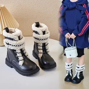 Stylish girls black Martin boots with warm white lamb wool trim and silver chain accents