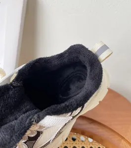 Detalle de zapatillas infantiles con forro de felpa negra suave para el invierno