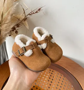 Close-up view of cozy toddler winter shoes with warm white faux fur lining and buckle strap