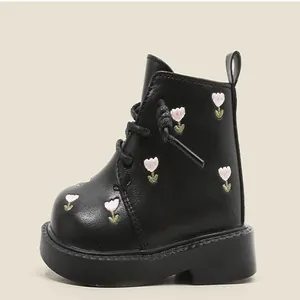 Detailed side view of black toddler girl leather boots with pink floral embroidery.