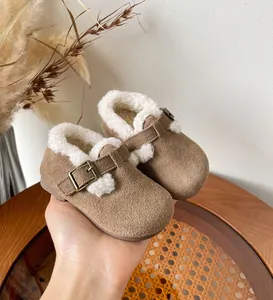 Detailed macro view of brown toddler winter shoes with cozy white fleece lining and buckle.