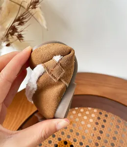 Flexible and warm fleece-lined brown suede toddler shoes showing extreme sole softness.