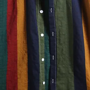 Gros plan détaillé d'une chemise pour homme à rayures multicolores en lin avec boutons blancs