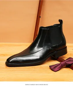 Primer plano detallado de bota Chelsea de cuero negro con grabados artísticos en el lateral