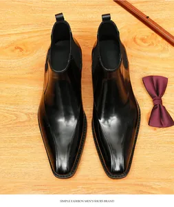 Vista superior detallada de botines Chelsea de cuero negro con punta fina en madera