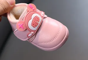 Nahaufnahme von rosa Baby-Schneestiefeln aus Leder mit warmem Futter und Zierstreifen.