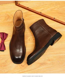 Detailed view of men's vintage brown leather boots with square toe design and side zipper