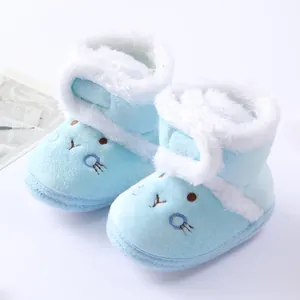 Detailed view of soft blue plush baby winter boots with cute cartoon face embroidery