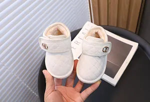 Close-up van witte baby snowboots met gewatteerd patroon en warme pluche voering