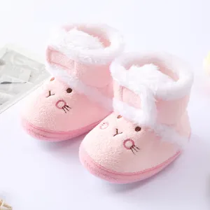 Close-up of cute pink plush baby snow boots with rabbit face design and white fur trim.