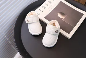 Close-up van witte gewatteerde babysneeuwlaarzen met pluche voering en klittenband