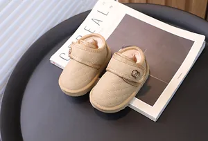 Detailopname van beige gewatteerde baby-sneeuwlaarzen met warme pluche voering en metalen ring