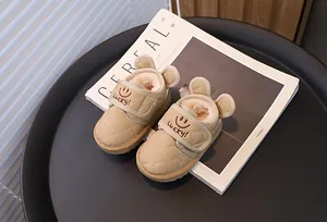 Close-up of baby snow boots with cute bear ears and "Lucky!" embroidery.
