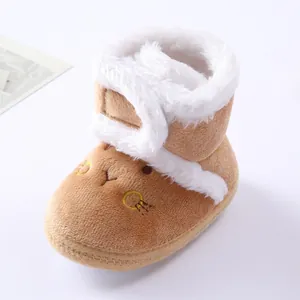 Close-up of soft brown plush baby winter boot with white fur trim and cute embroidery.